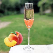 Peach popping boba added into a wine glass